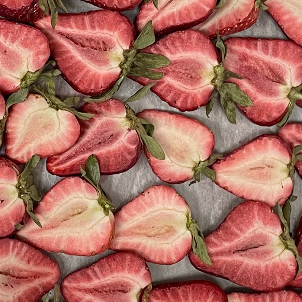 Close-up of sliced freeze-dried strawberries on a grey metal surface