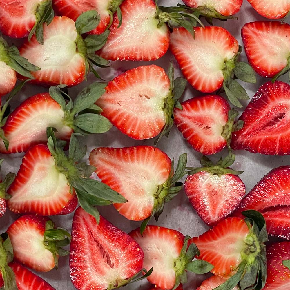 Close-up of sliced strawberries on a grey metal surface